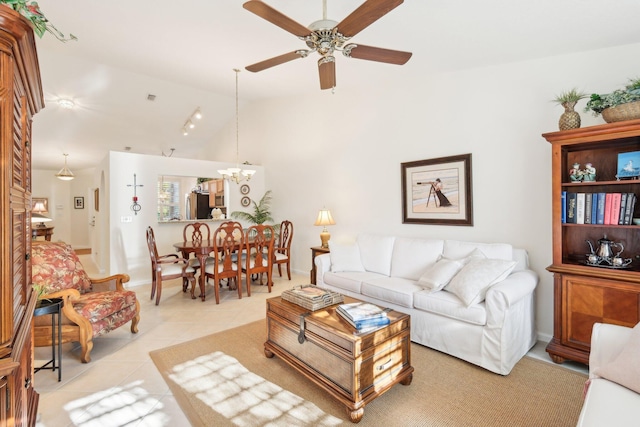 living room with lofted ceiling, light tile patterned floors, baseboards, and ceiling fan with notable chandelier