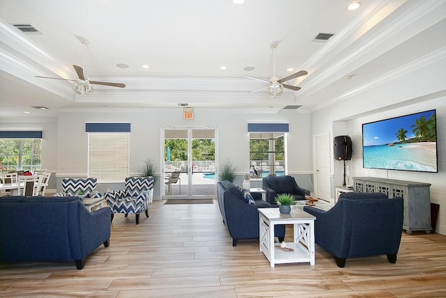 living room with plenty of natural light, a raised ceiling, and visible vents