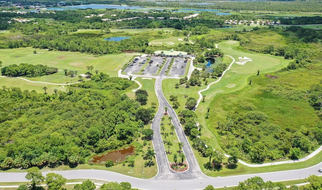 drone / aerial view with a water view and golf course view