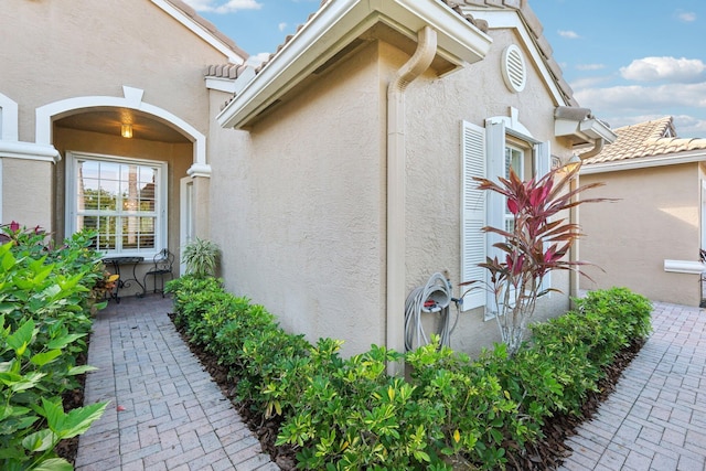 view of property exterior with a tiled roof and stucco siding