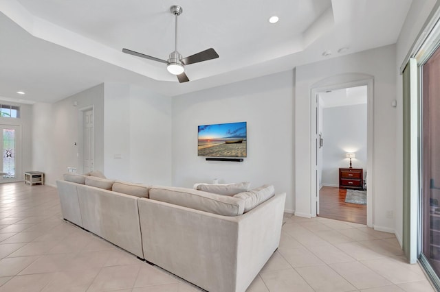 living area featuring recessed lighting, baseboards, a tray ceiling, and light tile patterned flooring