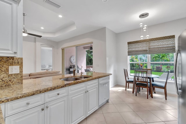 kitchen featuring visible vents, decorative backsplash, freestanding refrigerator, a sink, and dishwasher