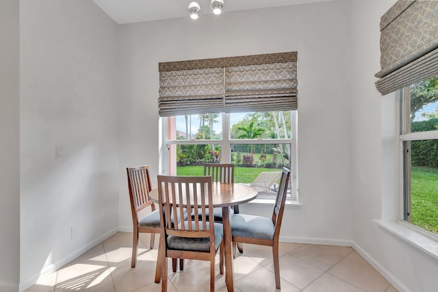 dining space featuring light tile patterned flooring and baseboards