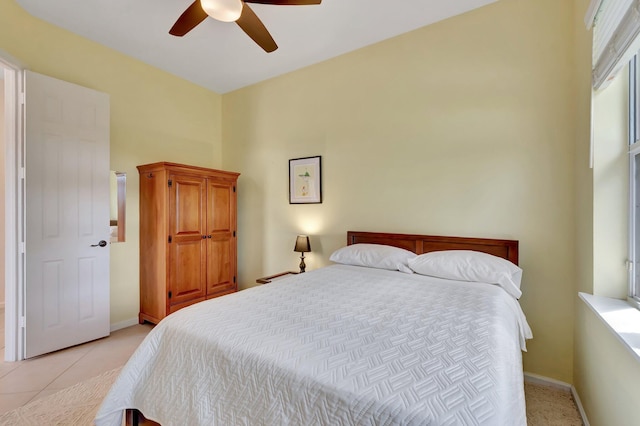 bedroom with light tile patterned flooring, ceiling fan, and baseboards