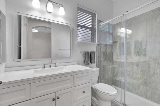 bathroom with a stall shower, vanity, and toilet