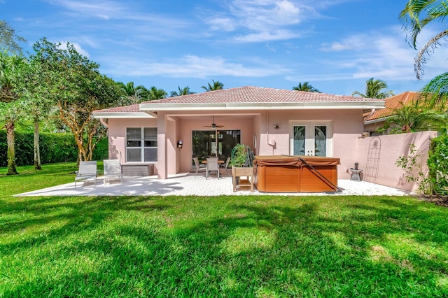 rear view of property featuring a patio, stucco siding, a hot tub, a ceiling fan, and fence