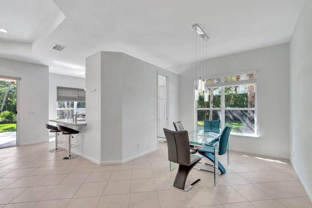 dining space featuring light tile patterned floors, plenty of natural light, visible vents, and baseboards