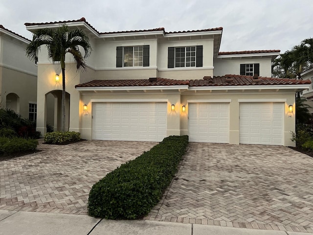 view of front of house featuring a garage, decorative driveway, and stucco siding