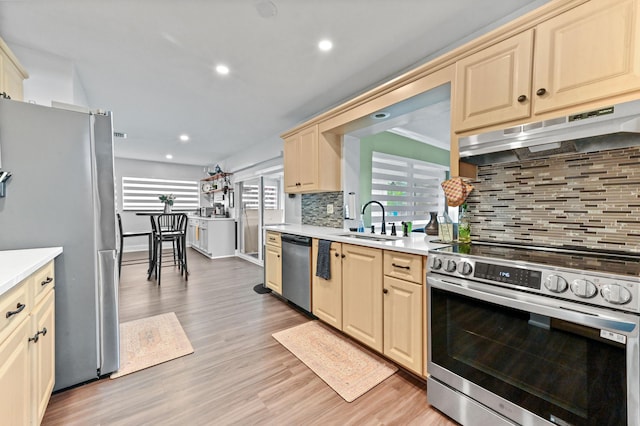 kitchen featuring light countertops, appliances with stainless steel finishes, a sink, and under cabinet range hood