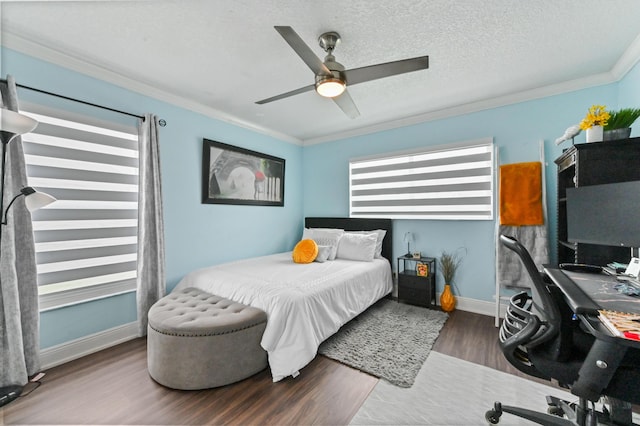 bedroom featuring ornamental molding, a ceiling fan, a textured ceiling, wood finished floors, and baseboards