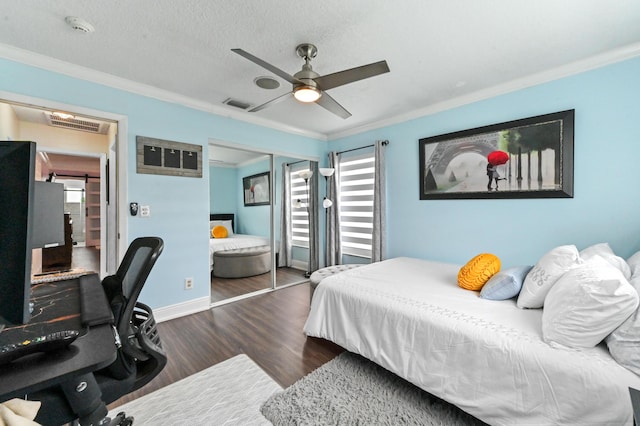 bedroom with a textured ceiling, wood finished floors, visible vents, ornamental molding, and a closet