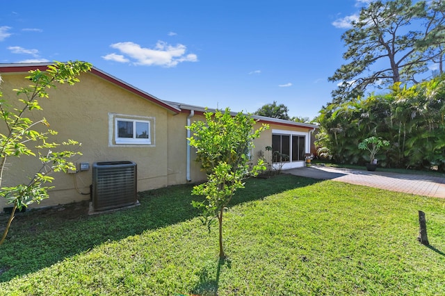 view of yard with decorative driveway and central AC