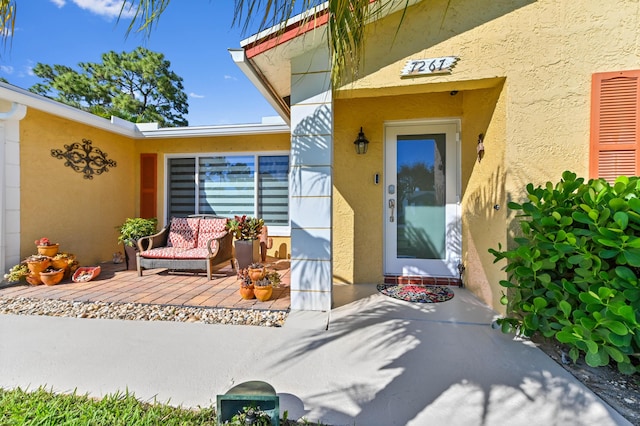 entrance to property featuring stucco siding