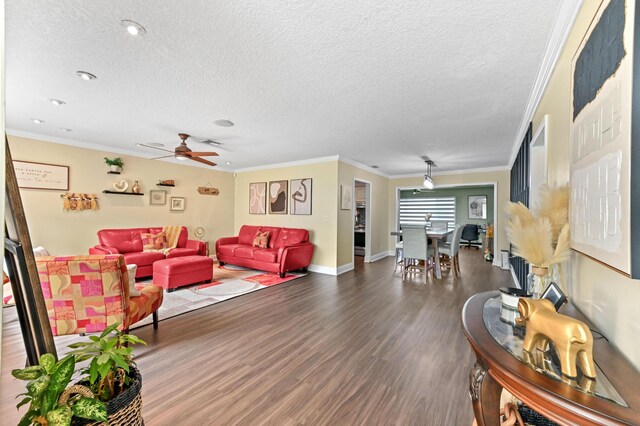 living area featuring ornamental molding, a textured ceiling, baseboards, and wood finished floors