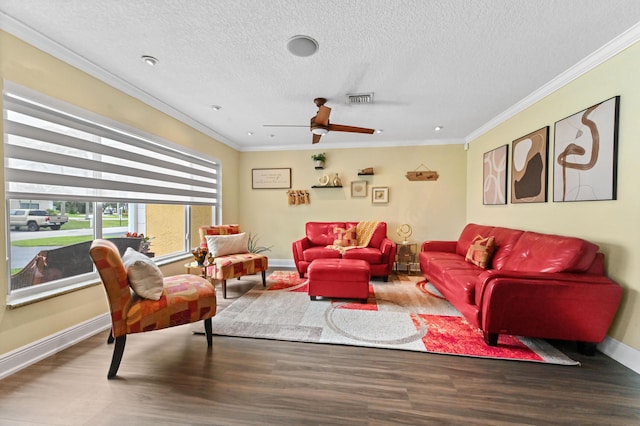 living room with ornamental molding, visible vents, baseboards, and wood finished floors