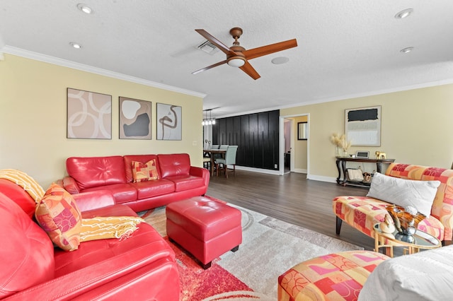 living room featuring a textured ceiling, ornamental molding, wood finished floors, and baseboards