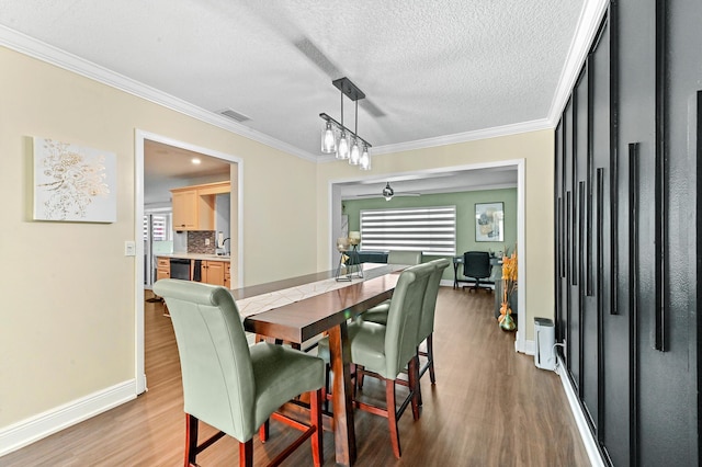 dining space featuring ornamental molding, visible vents, plenty of natural light, and wood finished floors