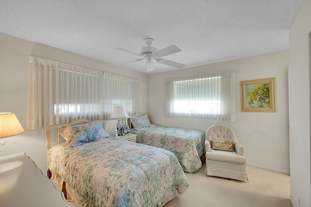 carpeted bedroom featuring a ceiling fan, baseboards, and a textured ceiling