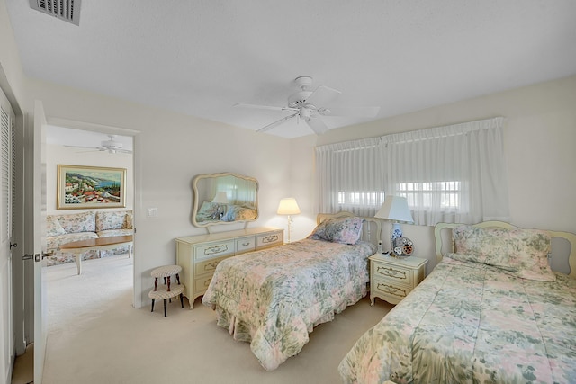 bedroom with light carpet, visible vents, and ceiling fan