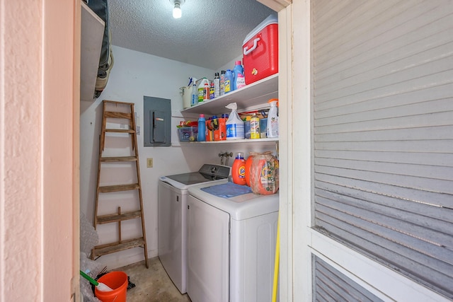 washroom featuring electric panel, laundry area, washer and dryer, and a textured ceiling