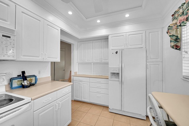 kitchen featuring white appliances, light countertops, white cabinetry, crown molding, and a raised ceiling