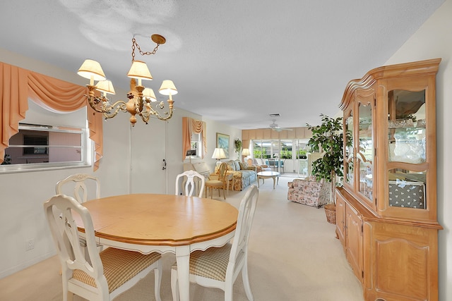 dining room featuring light colored carpet, a textured ceiling, and ceiling fan with notable chandelier