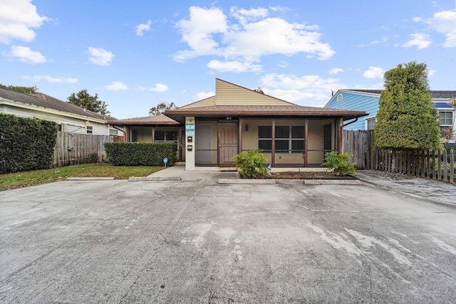 bungalow-style home with uncovered parking and fence