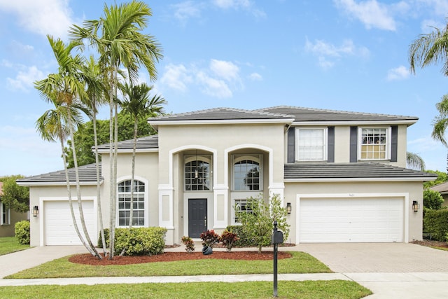 view of front of property with a garage, a tile roof, decorative driveway, and stucco siding