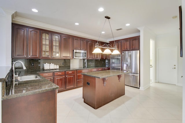 kitchen featuring stainless steel appliances, decorative backsplash, ornamental molding, a sink, and a kitchen breakfast bar