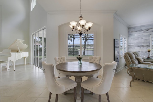 dining space featuring an accent wall, light tile patterned flooring, and crown molding