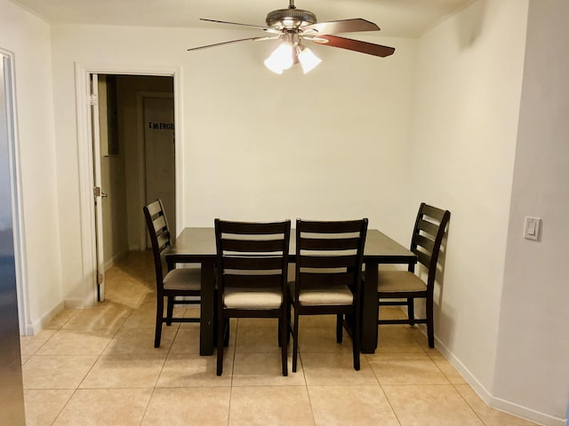 dining area featuring light tile patterned floors, baseboards, and a ceiling fan