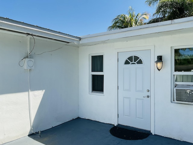 entrance to property featuring stucco siding