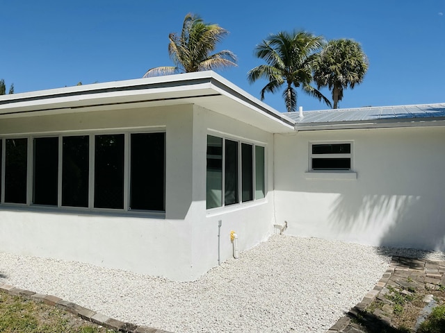 view of home's exterior with stucco siding and metal roof