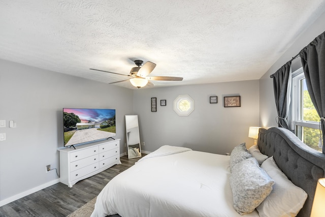 bedroom featuring baseboards, a ceiling fan, dark wood-style flooring, and a textured ceiling