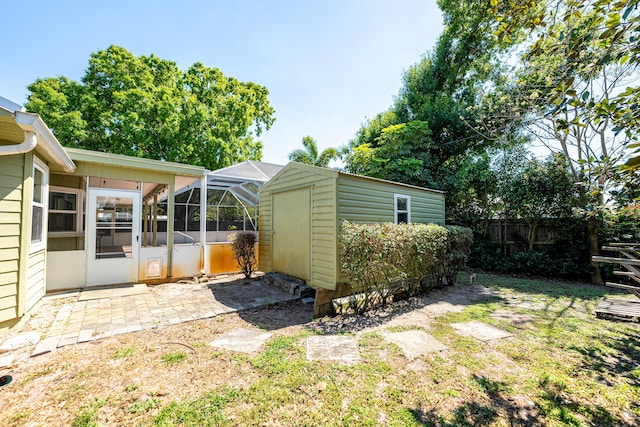 view of yard featuring fence, a shed, an outdoor structure, a lanai, and a patio area