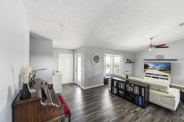 living area with a textured ceiling, wood finished floors, visible vents, and ceiling fan