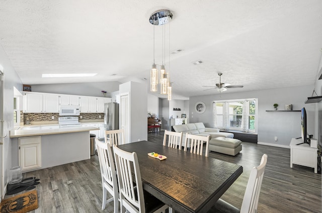 dining room featuring baseboards, lofted ceiling, dark wood-style flooring, ceiling fan, and a textured ceiling