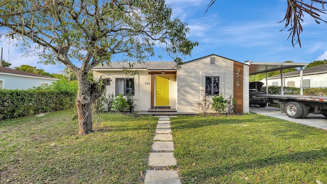 view of front facade featuring a front lawn, an attached carport, concrete driveway, and stucco siding