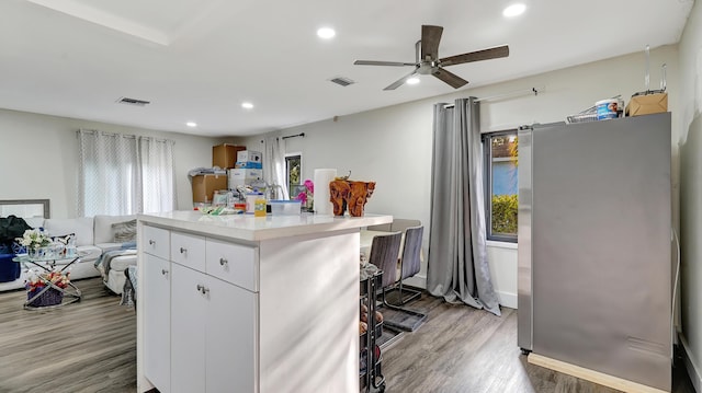 kitchen featuring a healthy amount of sunlight, light wood finished floors, visible vents, and freestanding refrigerator