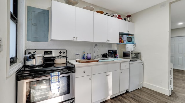 kitchen featuring wood finished floors, white cabinetry, light countertops, electric panel, and stainless steel electric stove