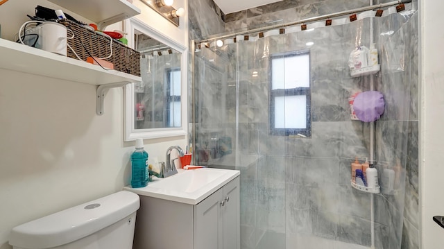 bathroom featuring toilet, a stall shower, and vanity