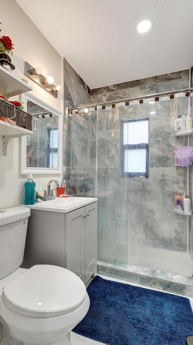 bathroom featuring a stall shower, vanity, and toilet