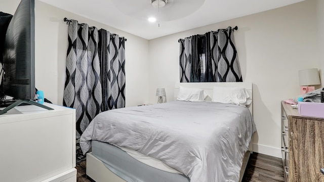 bedroom with ceiling fan, wood finished floors, and baseboards