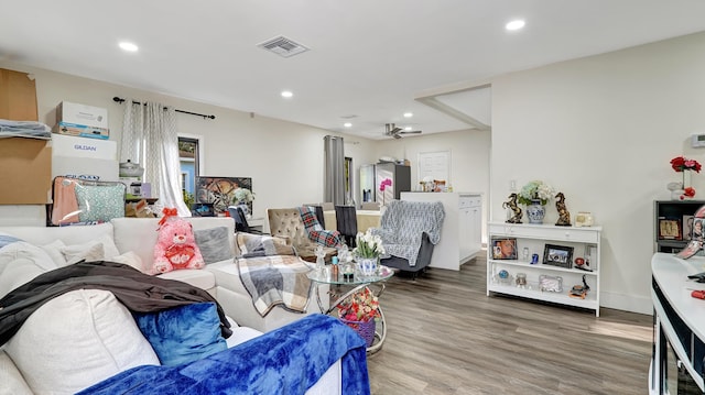 living area featuring baseboards, wood finished floors, visible vents, and recessed lighting