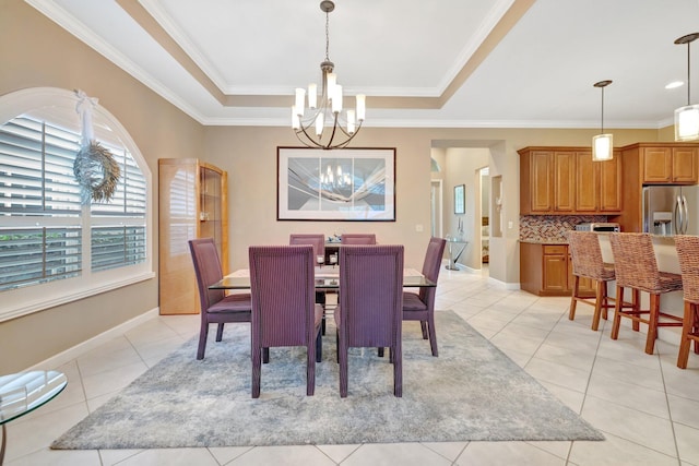 dining area featuring ornamental molding, a tray ceiling, an inviting chandelier, light tile patterned floors, and baseboards