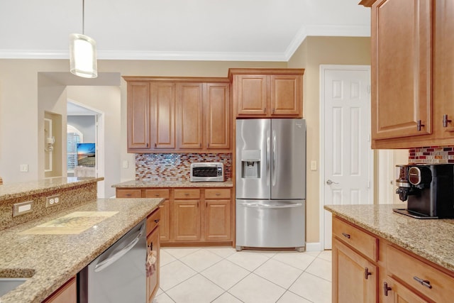 kitchen with pendant lighting, ornamental molding, stainless steel appliances, a toaster, and light stone countertops