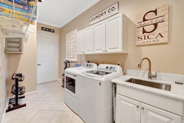 clothes washing area featuring ornamental molding, a sink, washing machine and dryer, cabinet space, and light tile patterned flooring