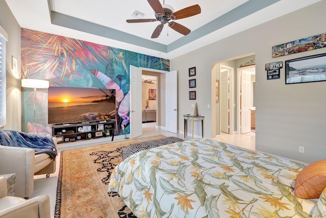 bedroom featuring visible vents, a raised ceiling, and a ceiling fan