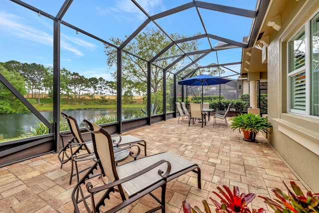 view of patio featuring a water view and a lanai