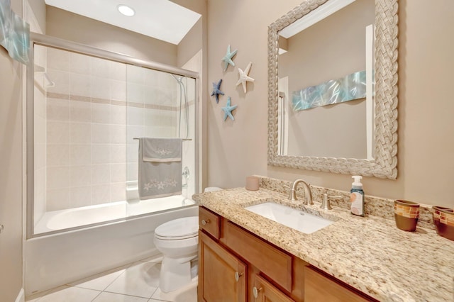 bathroom with vanity, tile patterned floors, toilet, and shower / bath combination with glass door